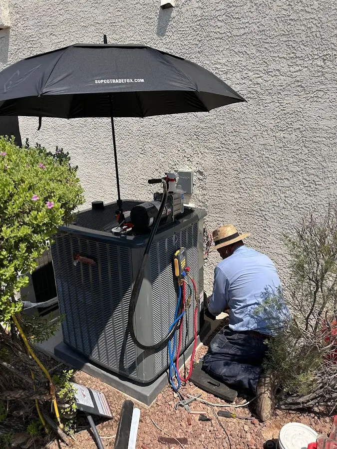 HVAC technician performing outdoor AC maintenance in North Elba